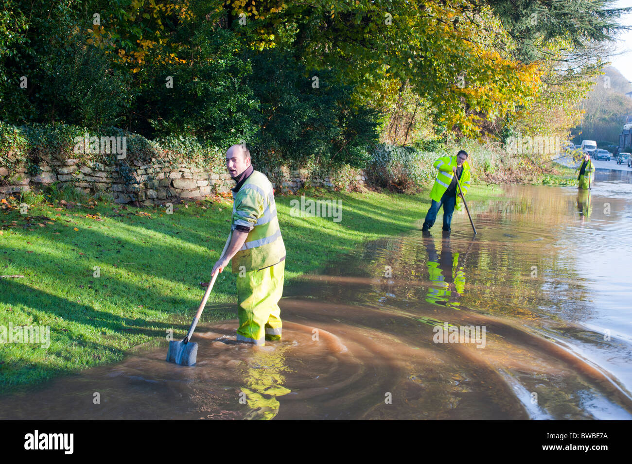 Lavoratori gara per cancellare gli scarichi bloccati dopo le inondazioni in Cornovaglia. La posizione A390 St Blazey Gate, 17 novembre 2010 Foto Stock