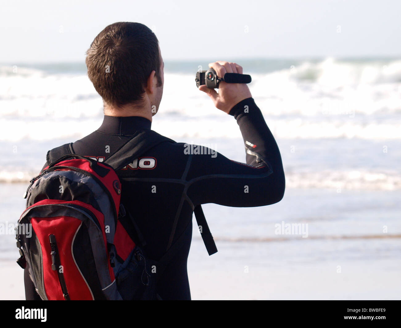 Surfer di riprese con una videocamera, Newquay, Cornwall, Regno Unito Foto Stock