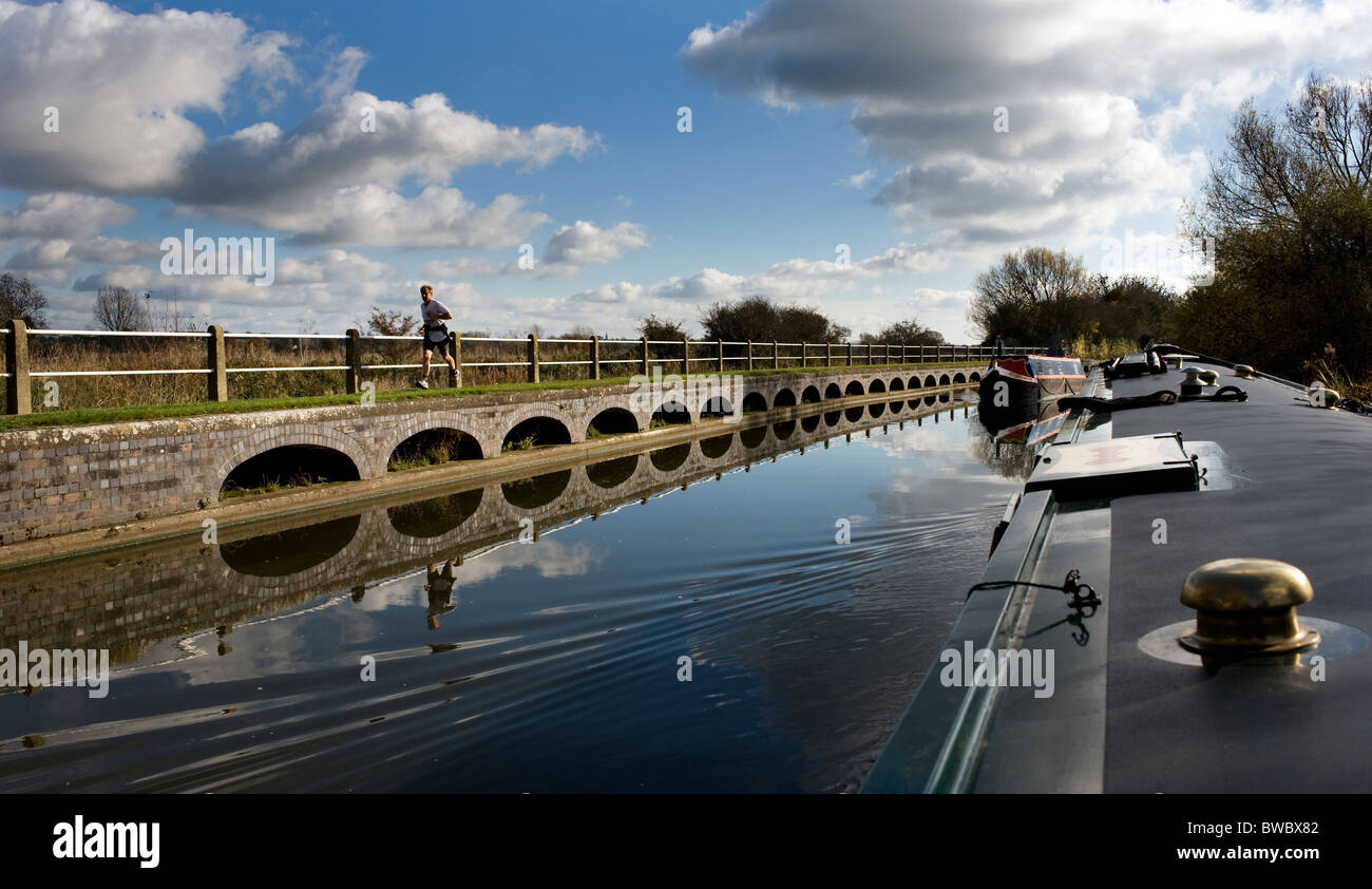 L'uomo jogging accanto al Grand Union Canal at Stoke bruerne northhampton Inghilterra Foto Stock