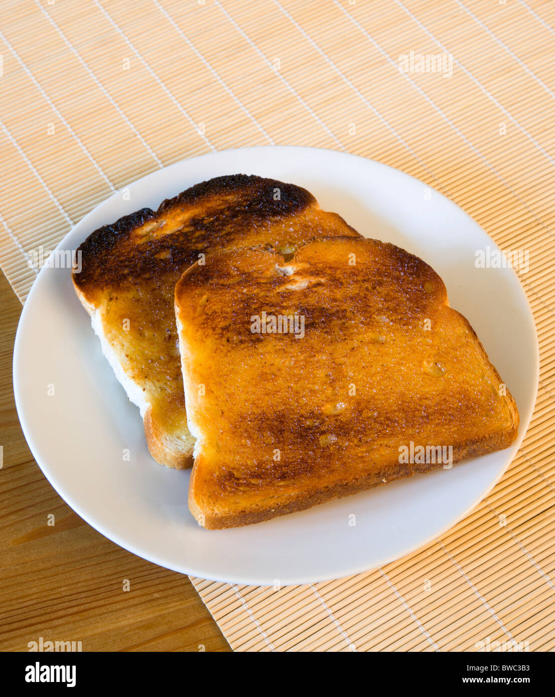 Alimenti cotti, pane, impostazione Tabella di due fette di pane tostato imburrato su una piastra. Foto Stock