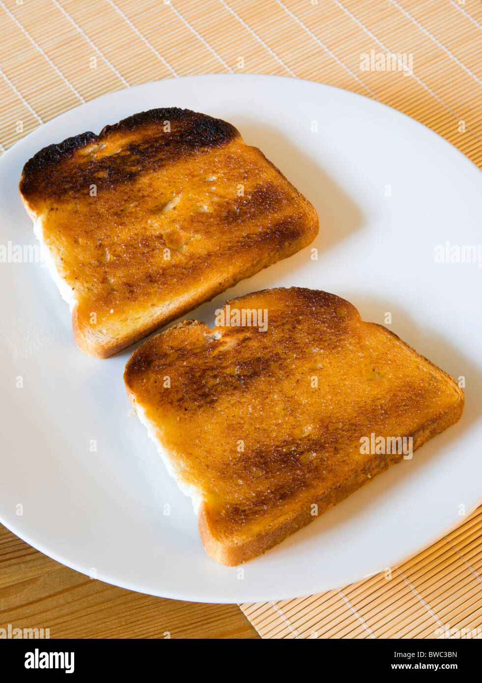 Alimenti cotti, pane, impostazione Tabella di due fette di pane tostato imburrato su una piastra. Foto Stock