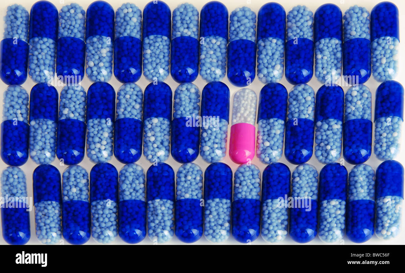 Un sacco di capsula blu medicina sullo sfondo bianco e una rosa Foto Stock