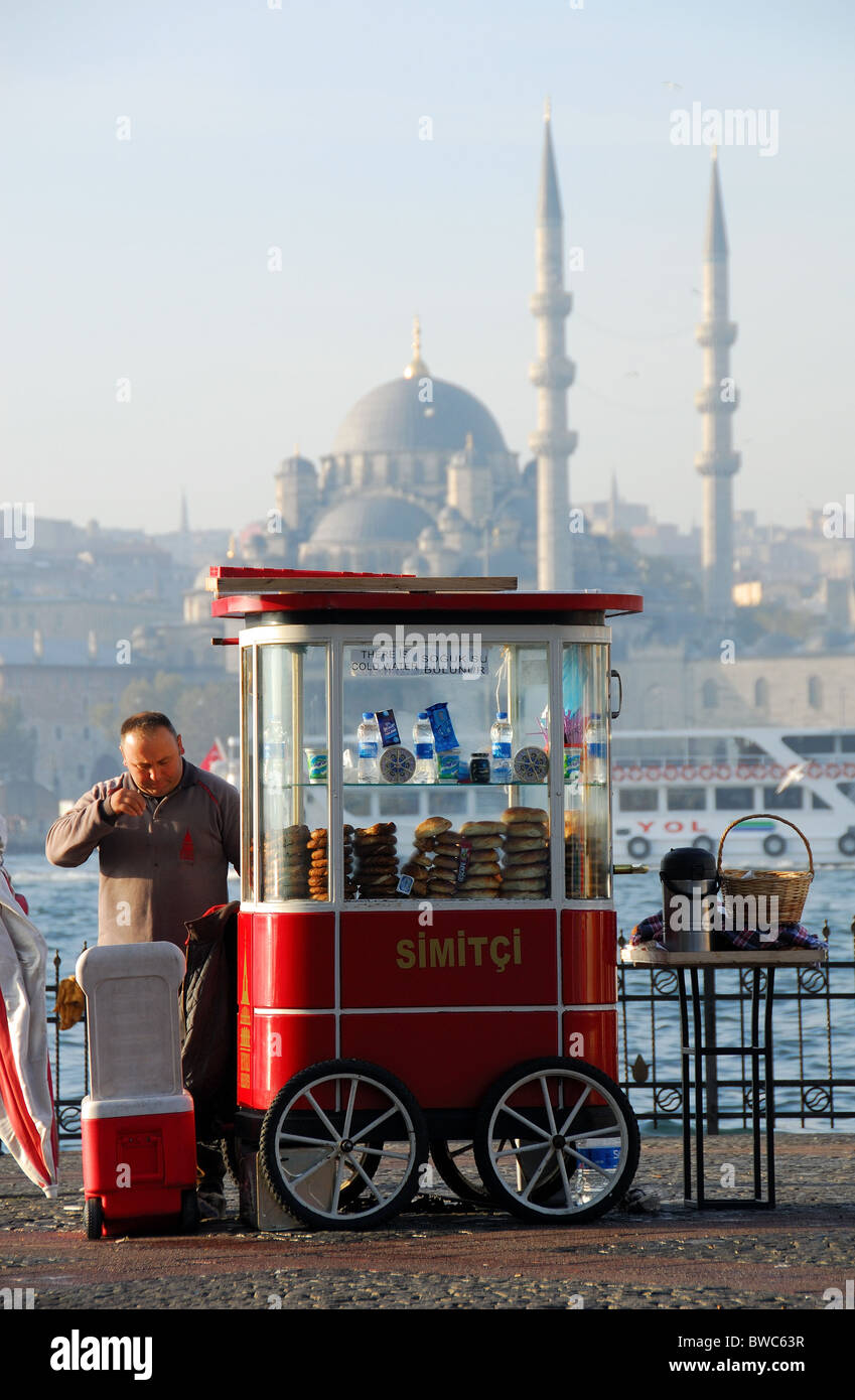 ISTANBUL, Turchia. Uno di Istanbul è onnipresente simit concessi in licenza ai fornitori con il Golden Horn e Moschea Yeni dietro. 2010. Foto Stock