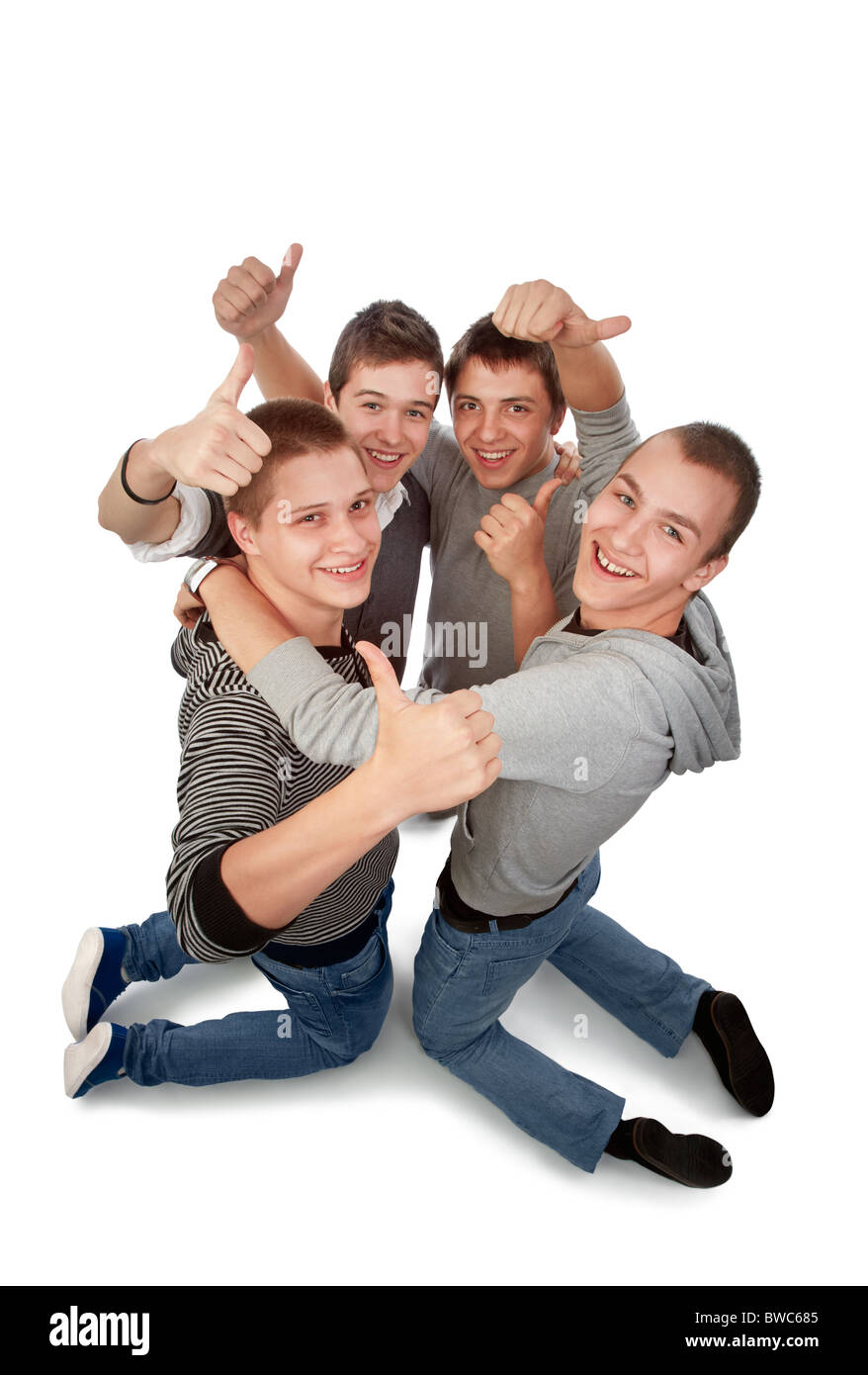 Quattro giovani amici si inginocchiò rallegrandosi per il loro successo Foto Stock