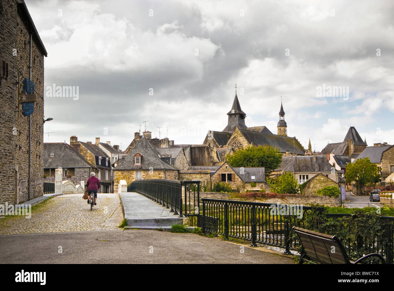 Donna ciclismo oltre il ponte di Malestroit, Morbihan, in Bretagna, in Francia, in Europa Foto Stock