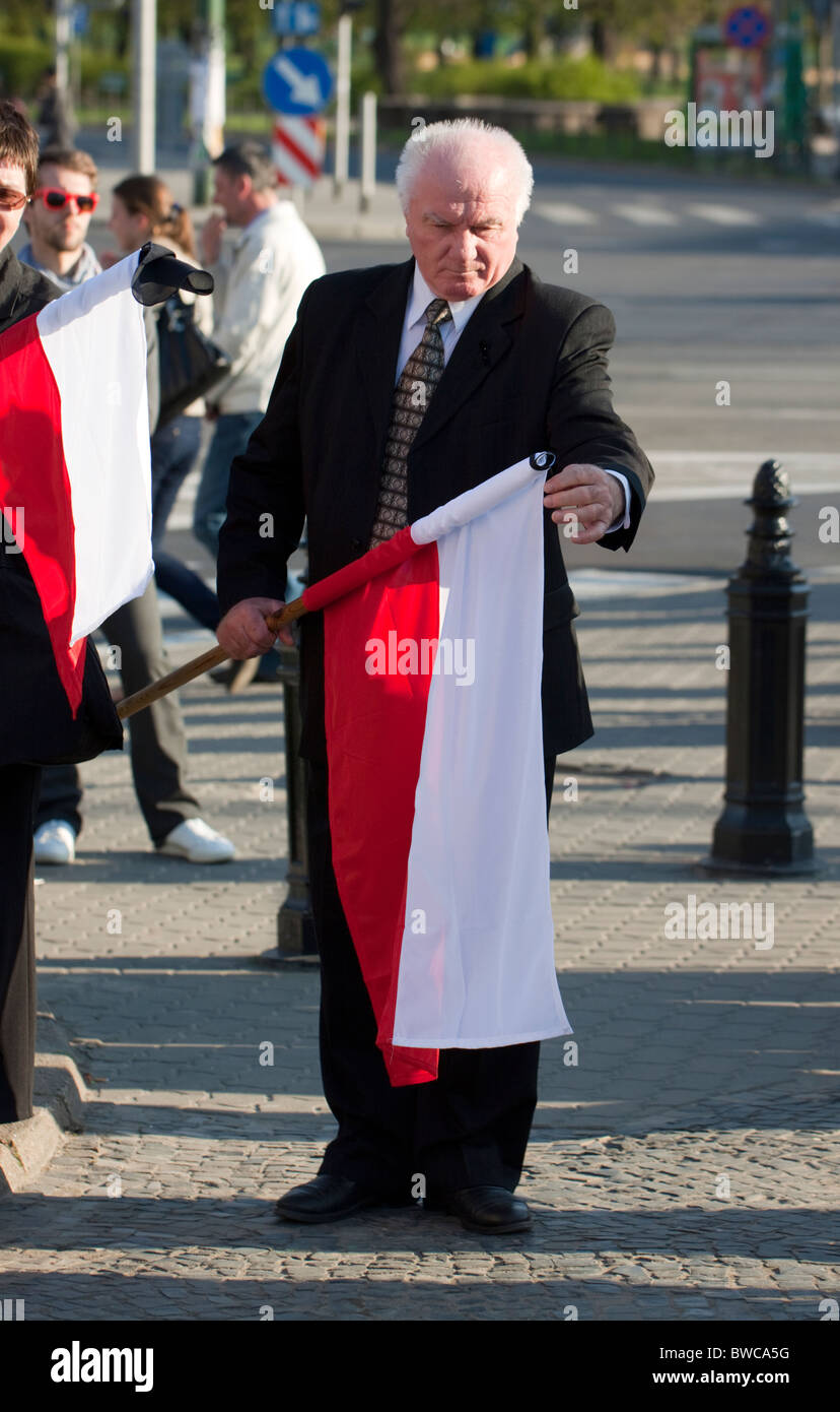 Uomo anziano tenendo una bandiera polacca il giorno della cerimonia funebre per tutti coloro che sono morti in Smolensk catastrofe, Poznan, Polonia Foto Stock