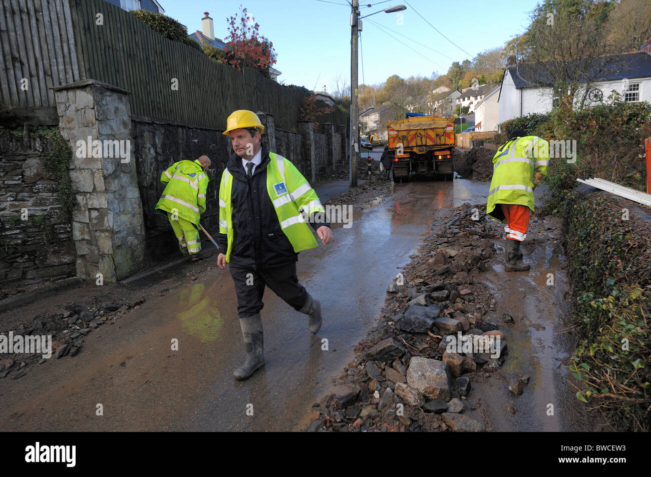 18/11/2010 il personale degli Enti locali per la pulizia coperti di fango road a Lostwithiel dopo allagamenti Foto Stock