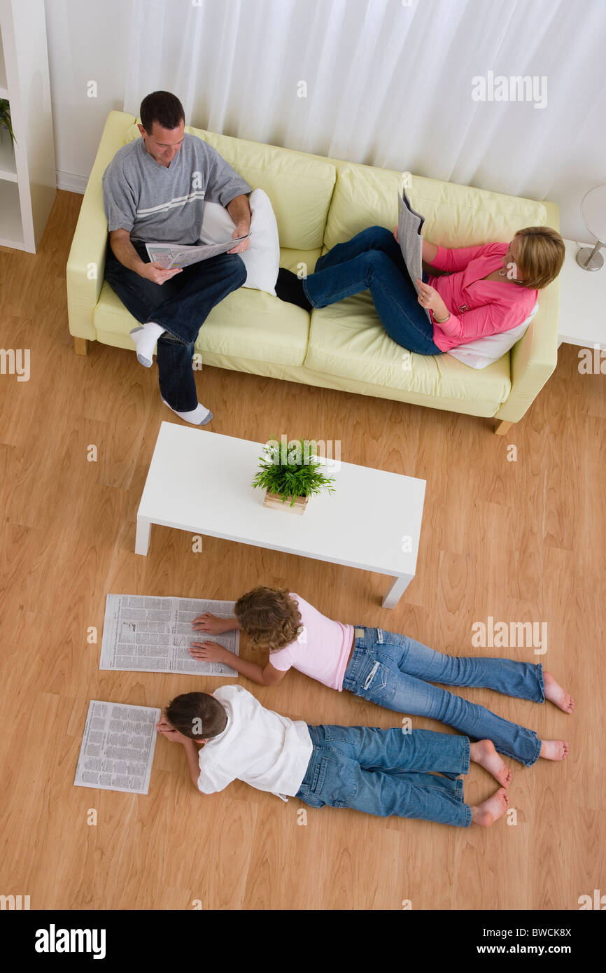 Stati Uniti d'America, Illinois, Metamora, Famiglia leggendo i giornali in salotto Foto Stock