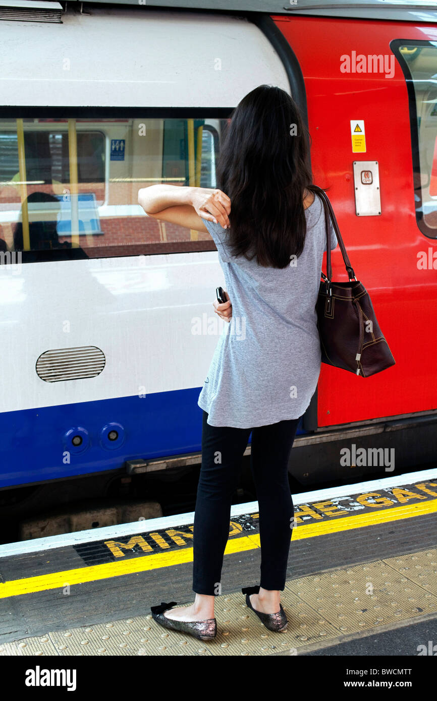 Sabato mattina, e una giovane donna passeggero attende una Londra della metropolitana per arrivare nel centro di Londra. DAVID MANSELL Foto Stock