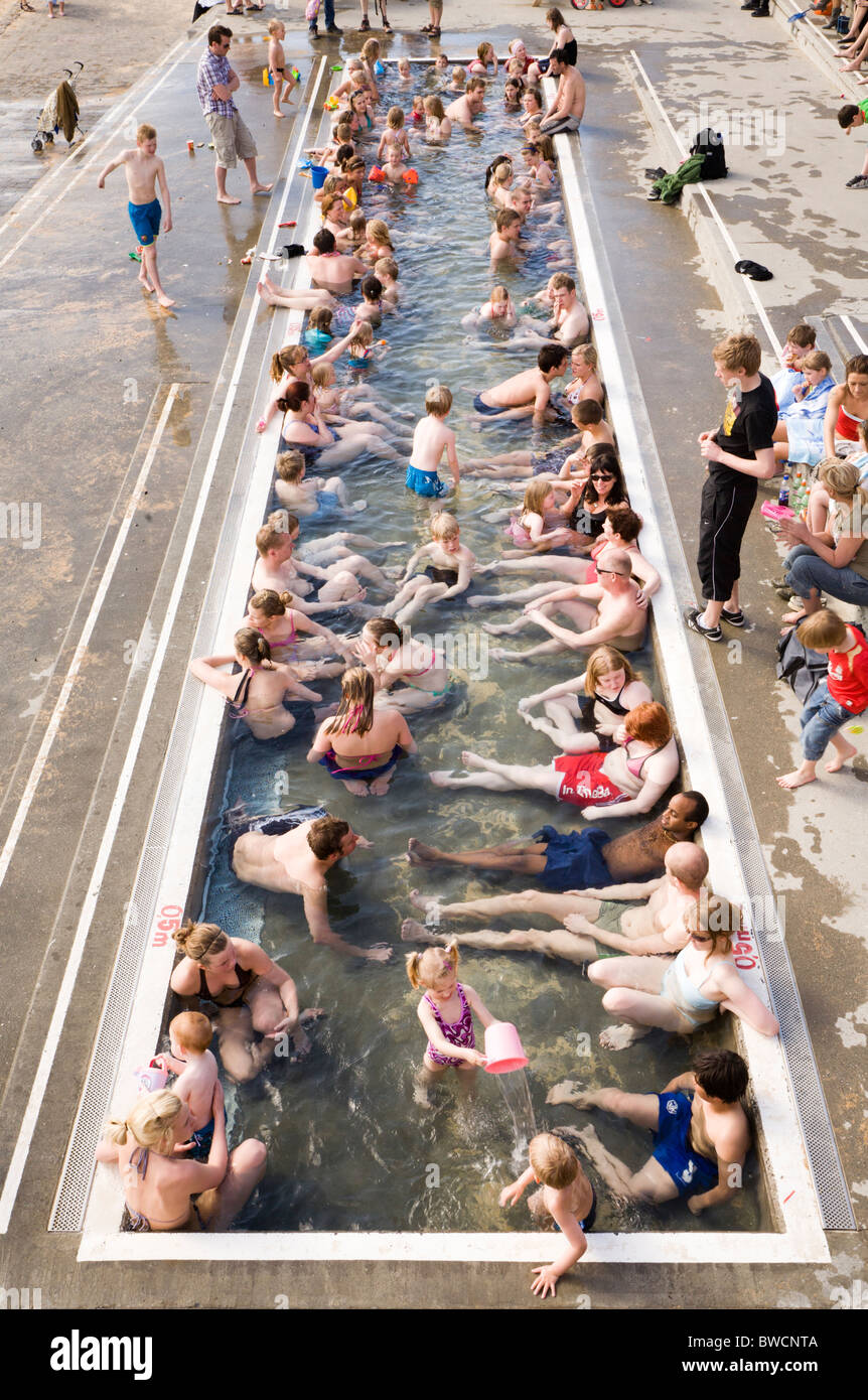 Le persone che si godono la giornata in spiaggia Nautholsvik, Reykjavik, Islanda. L'acqua viene riscaldata con acqua geotermica. Foto Stock
