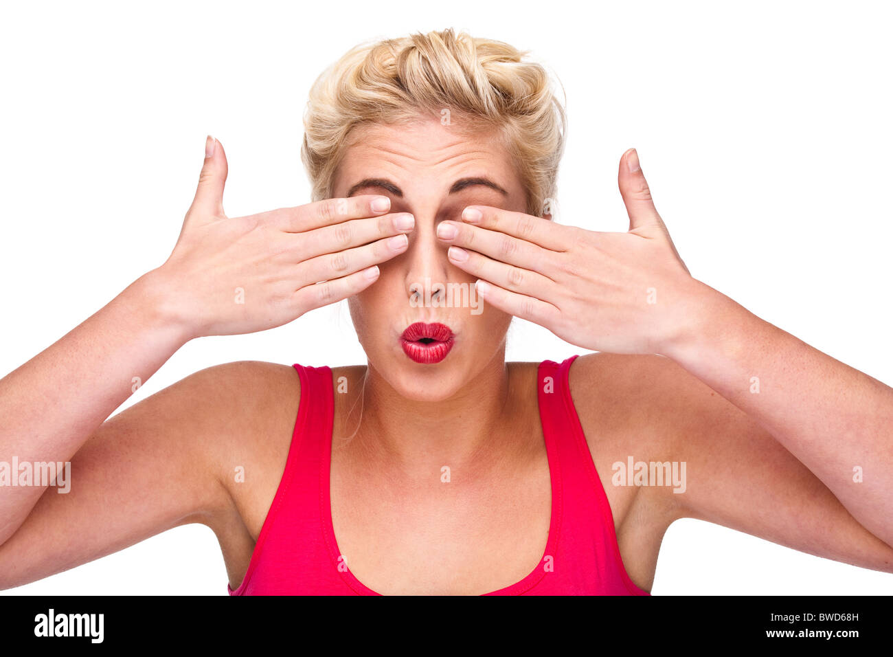 Vedere alcun male - giovane e bella donna bionda Cheeky espressione nasconde i suoi occhi Foto Stock