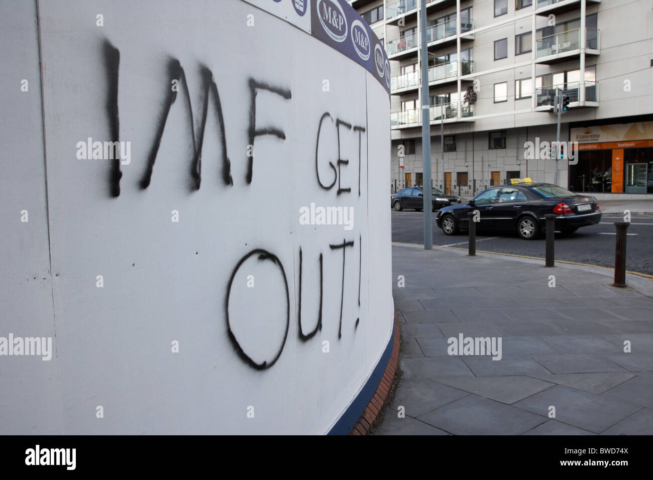 Dublino Repubblica di Irlanda. Fresh Anti FMI graffiti su un sito di costruzione parete in un affluente area di Dublino Foto Stock