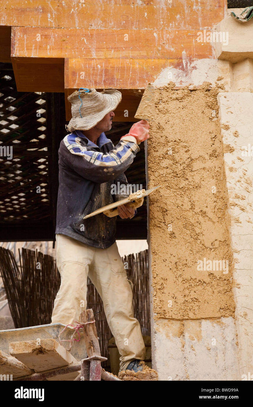 Un lavoratore di effettuare riparazioni su un edificio nella medina, la città vecchia di Fes, Marocco. Foto Stock