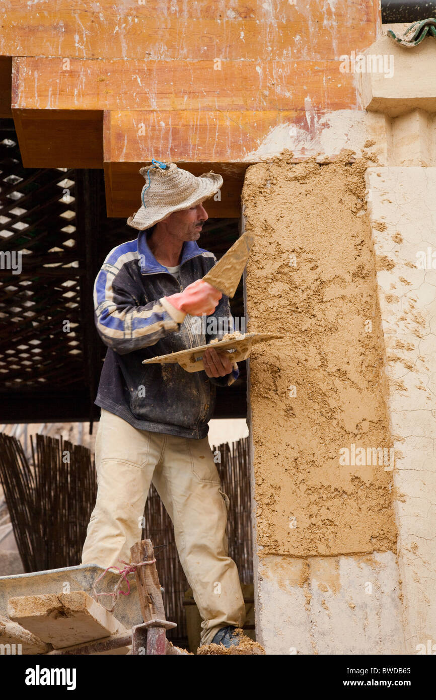 Un lavoratore di effettuare riparazioni su un edificio nella medina, la città vecchia di Fes, Marocco. Foto Stock