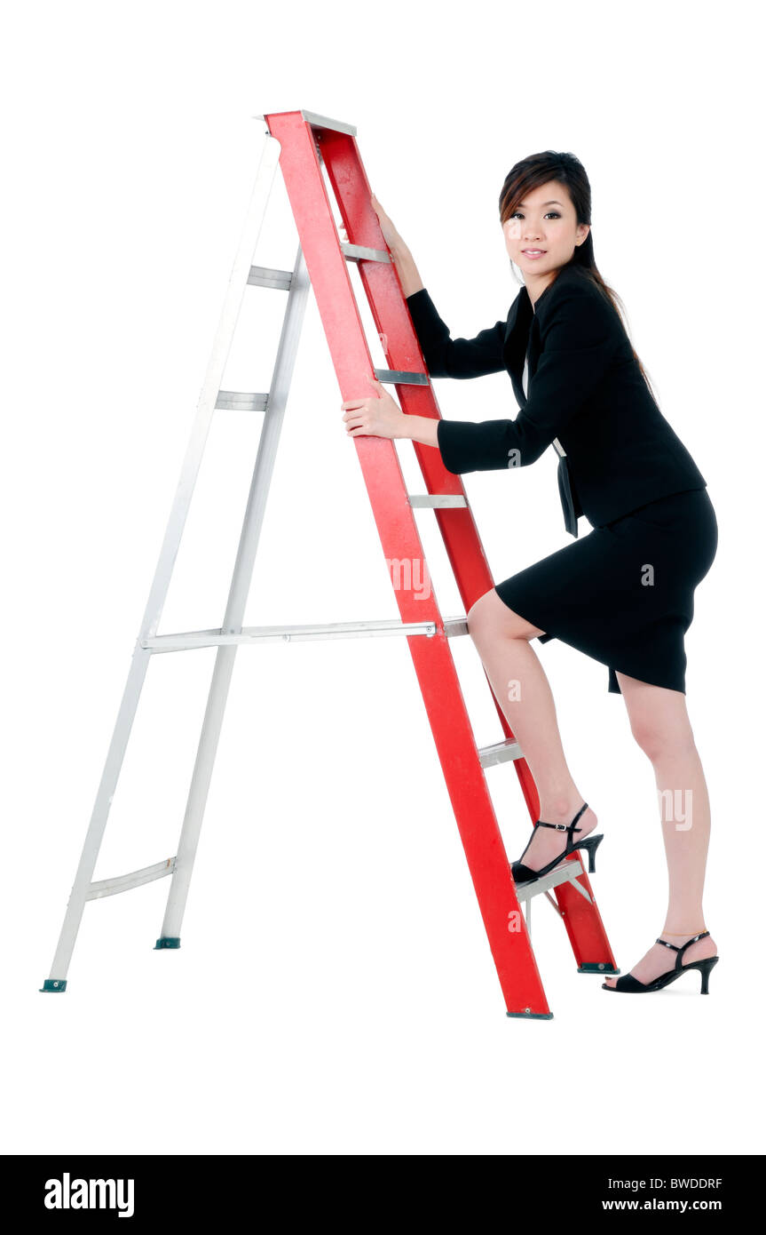 Attraente giovane imprenditrice salire una scala a pioli Foto Stock