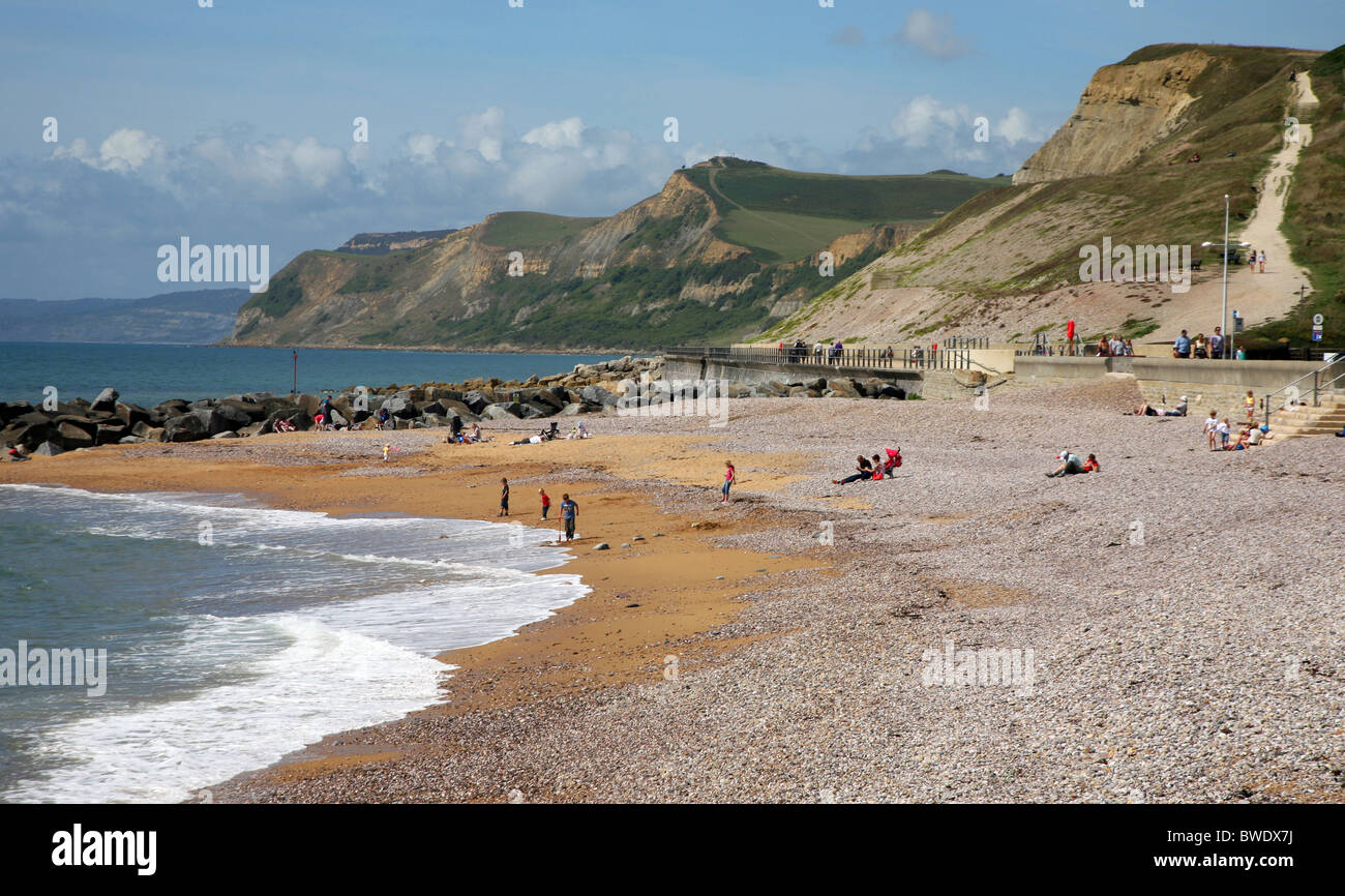 La spiaggia guardando ad ovest che mostra le scogliere della Jurassic Coast da West Bay, un popolare West Dorset località balneare vicino a Bridport Foto Stock