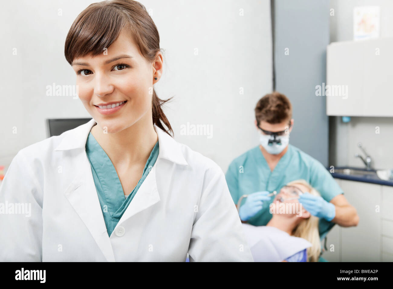 Ritratto di un assistente dentale sorridente con odontoiatria lavoro in background Foto Stock