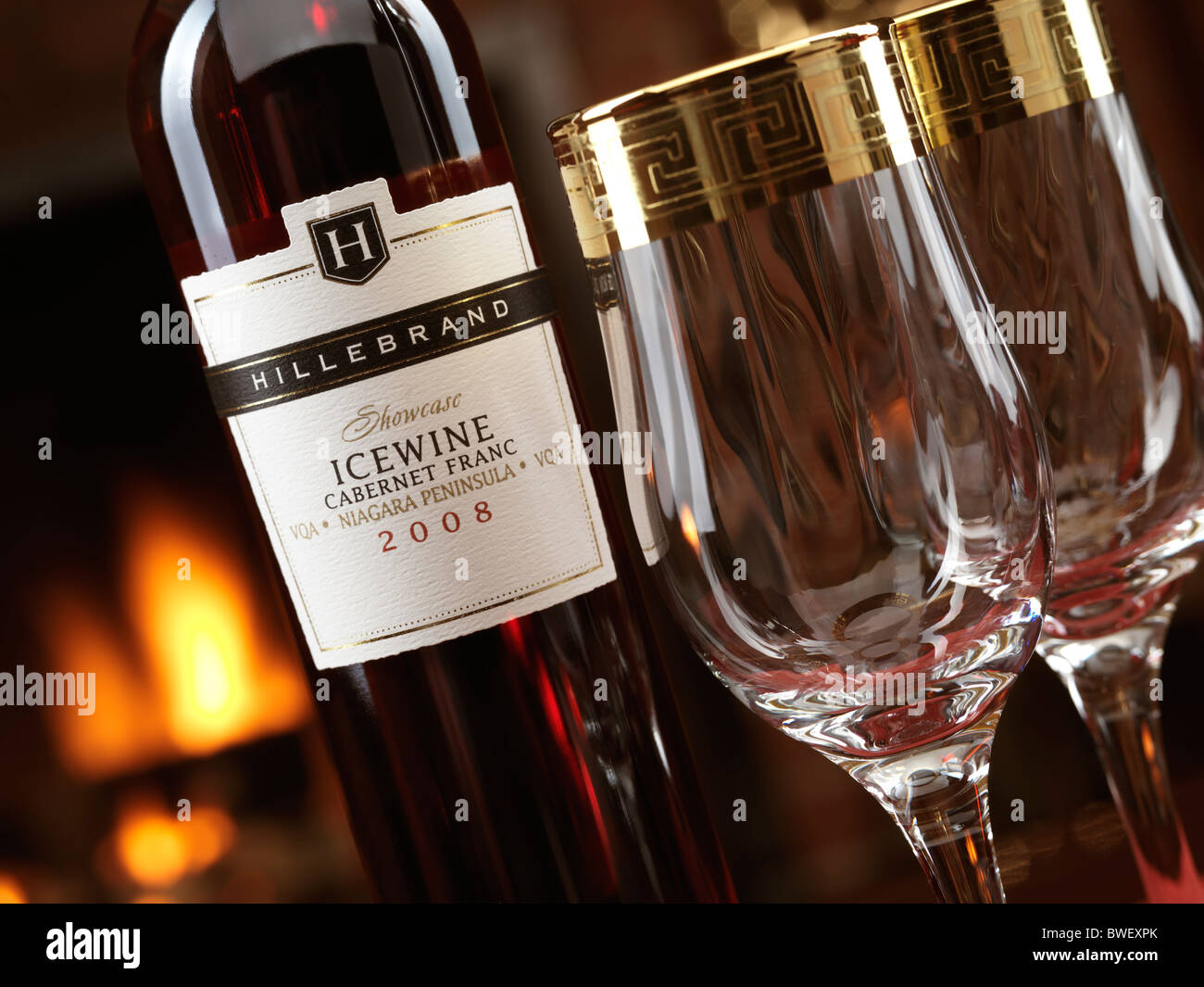Bottiglia di Rosso Icewine Cabernet Franc da Hillebrand e due bicchieri di vino davanti a un caminetto Foto Stock