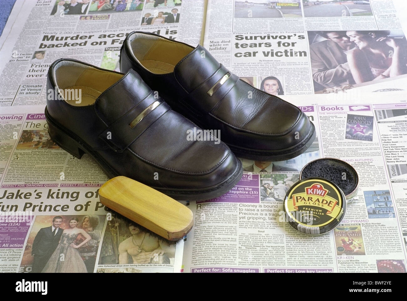 Coppia di marca Clarks Mens nero scarpe di cuoio sul giornale con Kiwi Brand Shoe Polish e spazzola Foto Stock