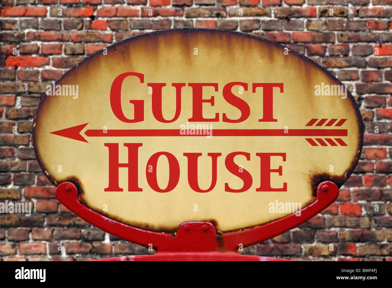 Un vecchio arrugginito retrò segno di freccia con il testo Guest house Foto Stock