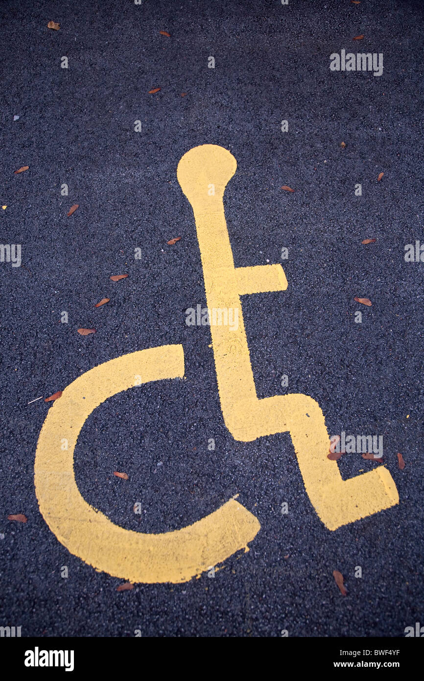 Sedia a rotelle disabili legati persona simbolo sulla pista di un bollino blu lo spazio per parcheggiare in un parcheggio Foto Stock
