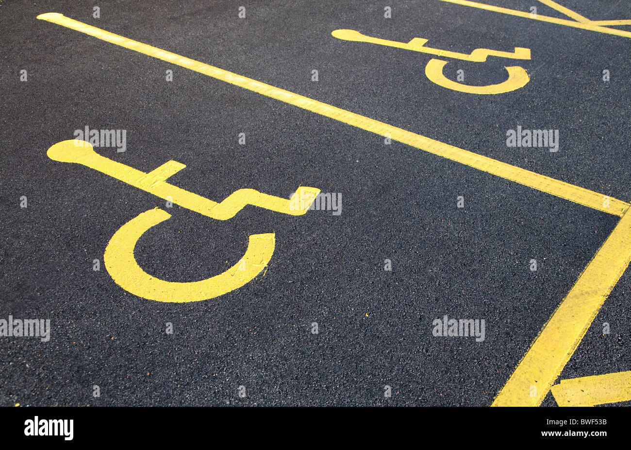 Sedia a rotelle disabili legati persona simbolo sulla pista di un bollino blu lo spazio per parcheggiare in un parcheggio Foto Stock