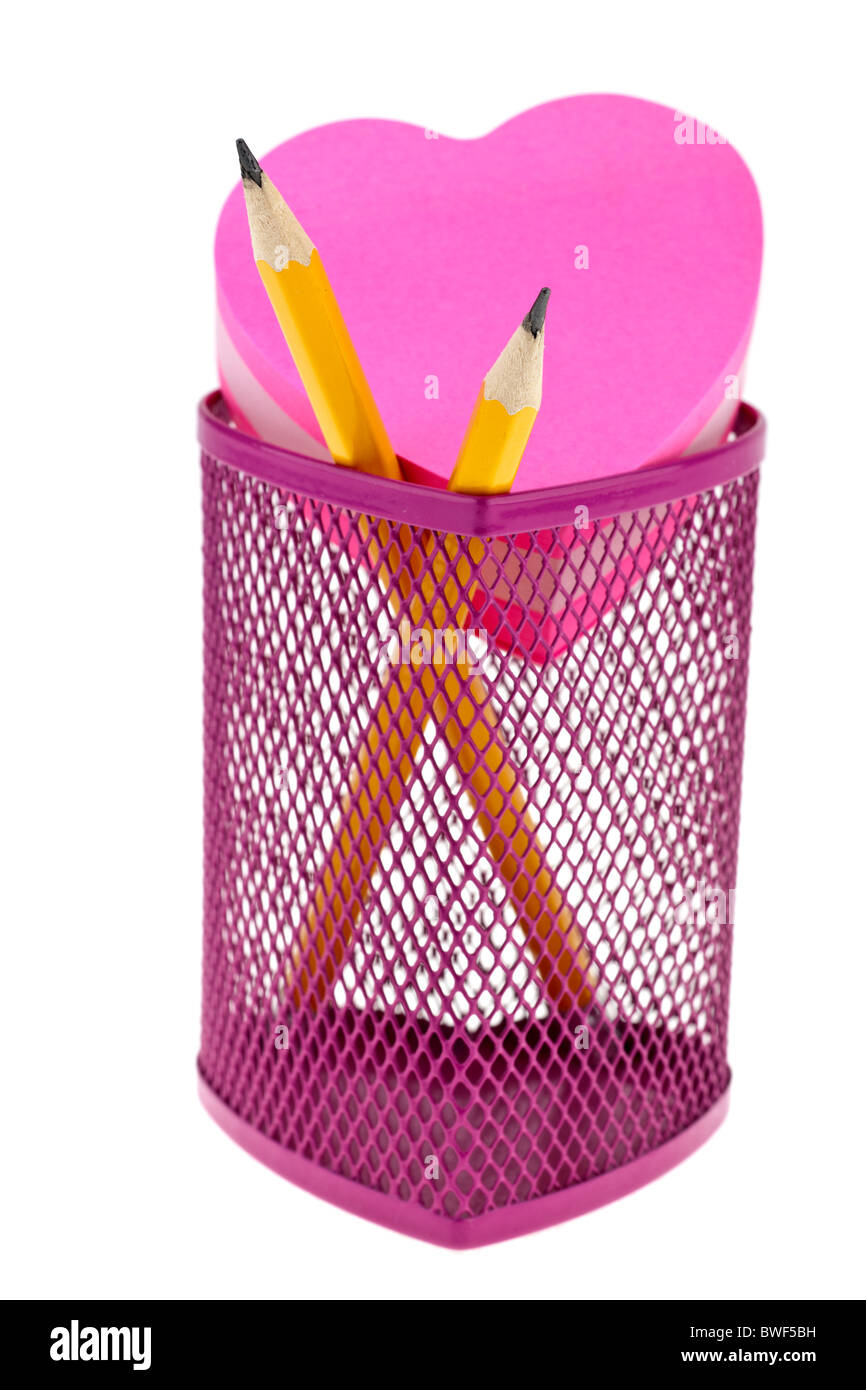 Rosa pentola a matita e matite di colore giallo con il cuore a forma di tampone jotter Foto Stock