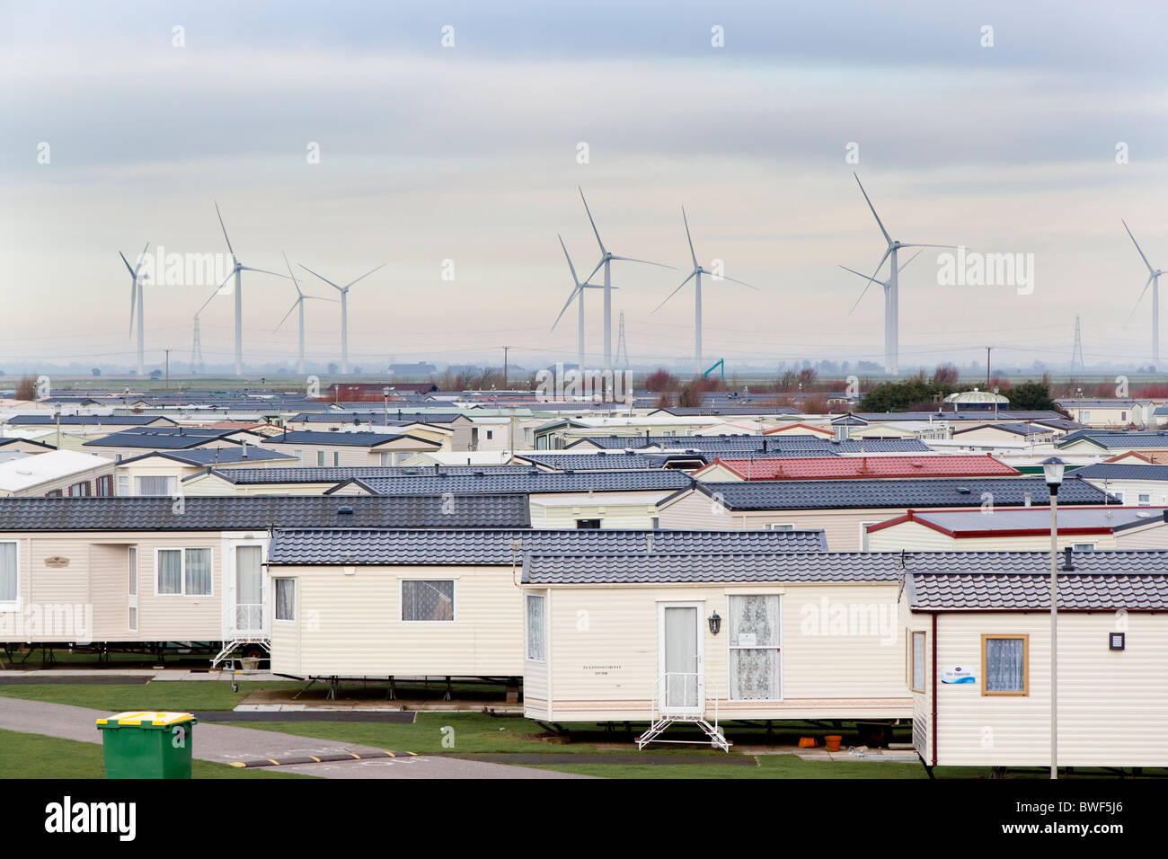 Camber Sands Holiday Park con le turbine di piccola corte Cheyne wind farm in background, East Sussex, Regno Unito Foto Stock