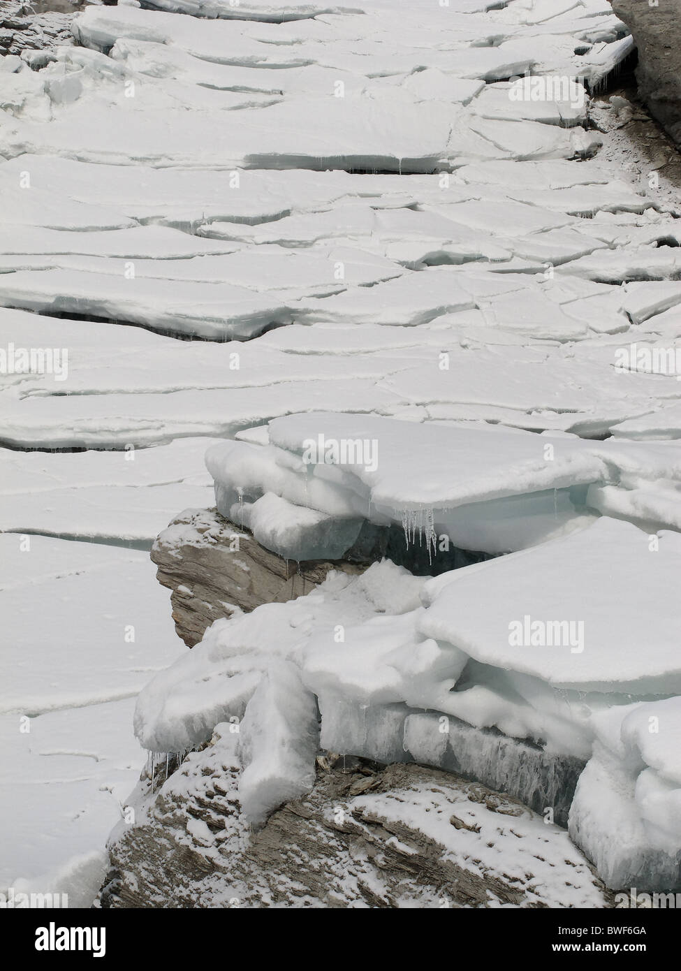 Lastre di ghiaccio a sinistra dietro abbassando i livelli delle acque del lago d'inverno. Lac des Dix, Svizzera. Foto Stock