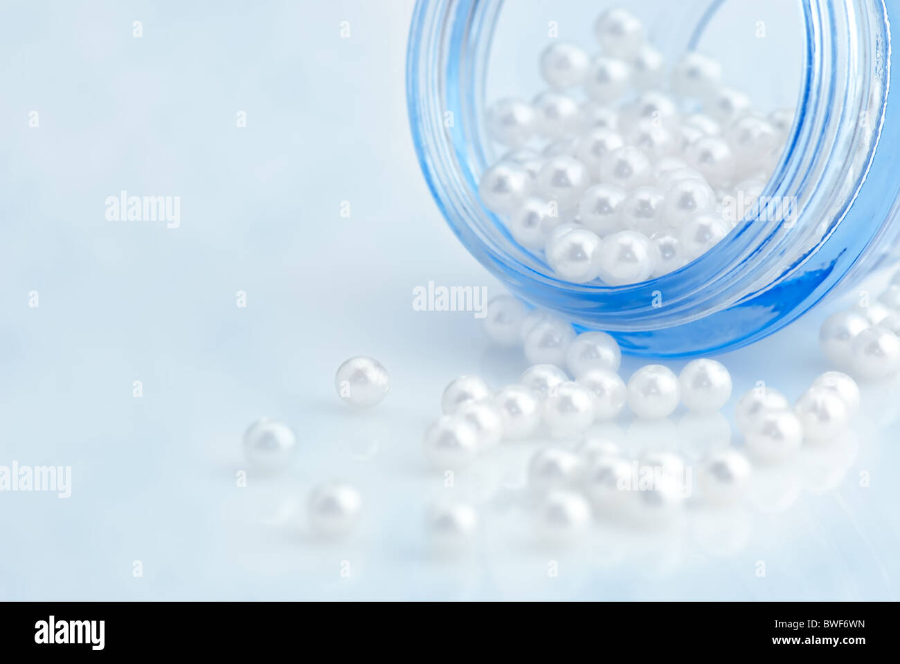 Concetto di bellezza:contenitore cosmetico pieno di perle naturali Foto Stock