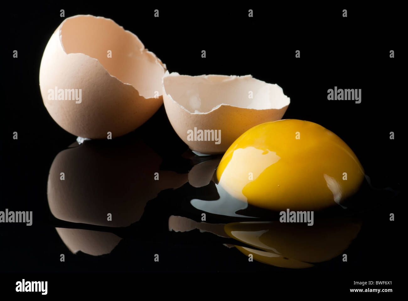 Uovo rotto su nero Foto Stock
