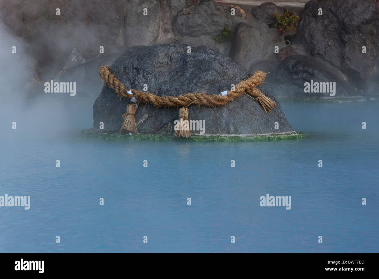 Una corda sacra chiamato Shimenawa drapped su una roccia in Umi Jigoku (Mare Inferno), uno degli inferni di Beppu, Oita, Giappone Foto Stock