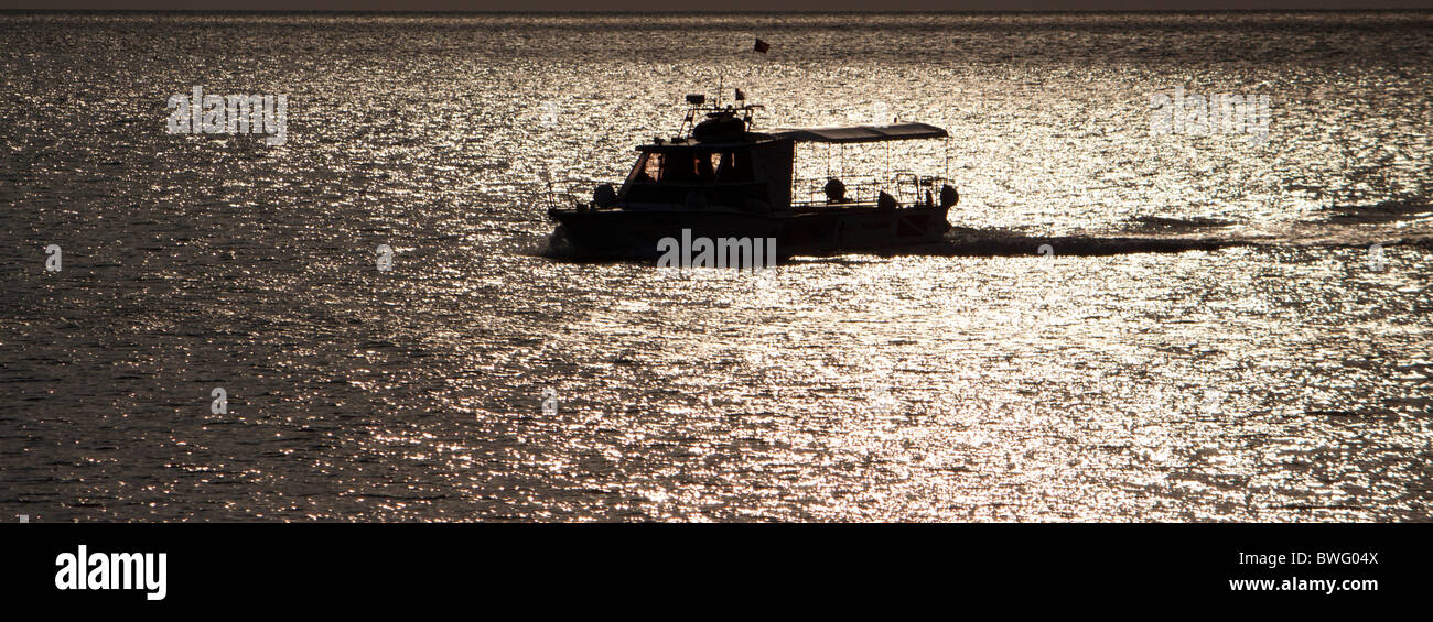 Barca da pesca stagliano contro la luce della sera Rovigno Foto Stock