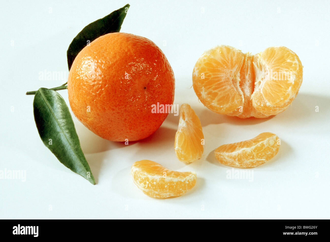 Clementina (Citrus aurantium x). Tutta la frutta sbucciata e sezioni. Studio shot contro uno sfondo bianco. Foto Stock