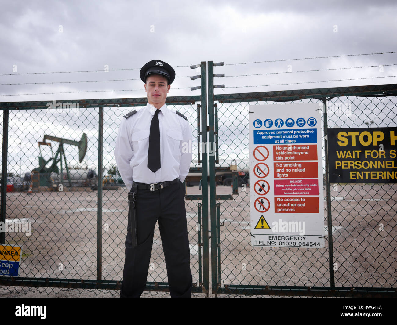 La guardia di sicurezza al cancello del pozzo petrolifero Foto Stock