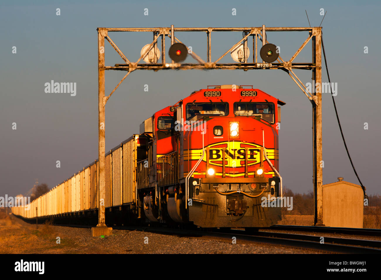 Un BNSF del carbone in treno in tarda serata la luce del sole sulle pianure del Midwest. Foto Stock