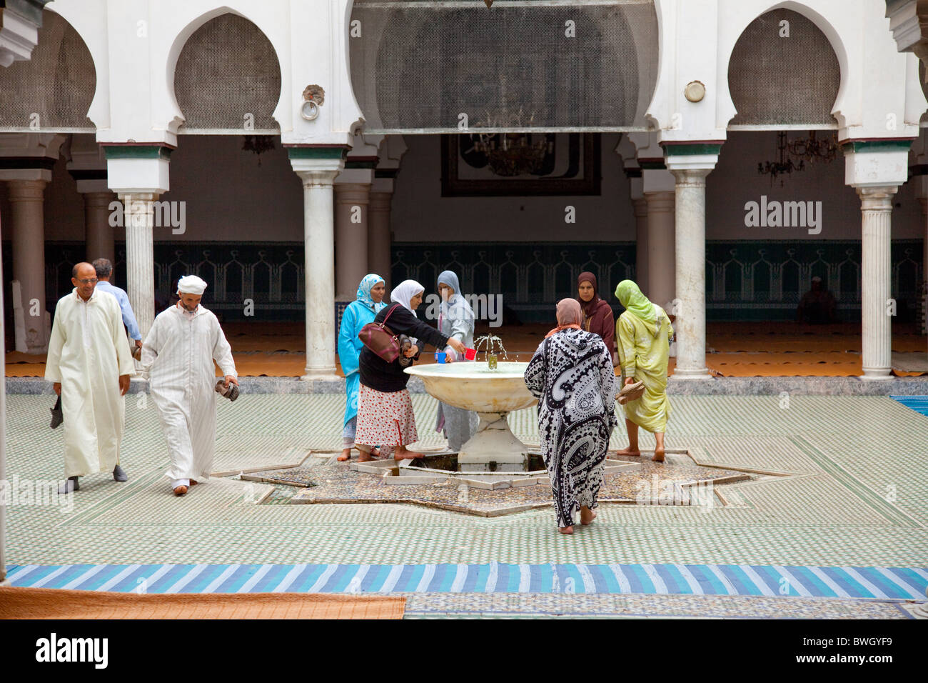 Islamic adoratori di purificare se stessi in corrispondenza di una abluzione fontana a una moschea nella Medina, la città vecchia di Fes, Marocco. Foto Stock