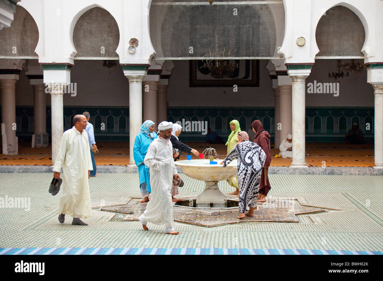 Islamic adoratori di purificare se stessi in corrispondenza di una abluzione fontana a una moschea nella Medina, la città vecchia di Fes, Marocco. Foto Stock