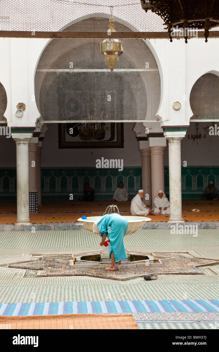 Islamic adoratori di purificare se stessi in corrispondenza di una abluzione fontana a una moschea nella Medina, la città vecchia di Fes, Marocco. Foto Stock