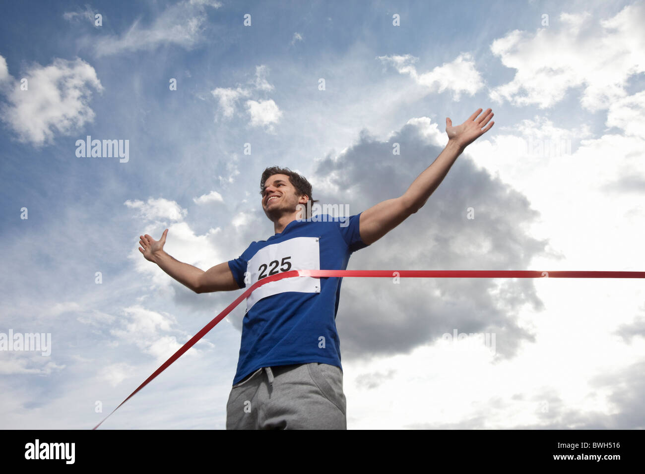 Giovane uomo Attraversamento linea di finitura Foto Stock