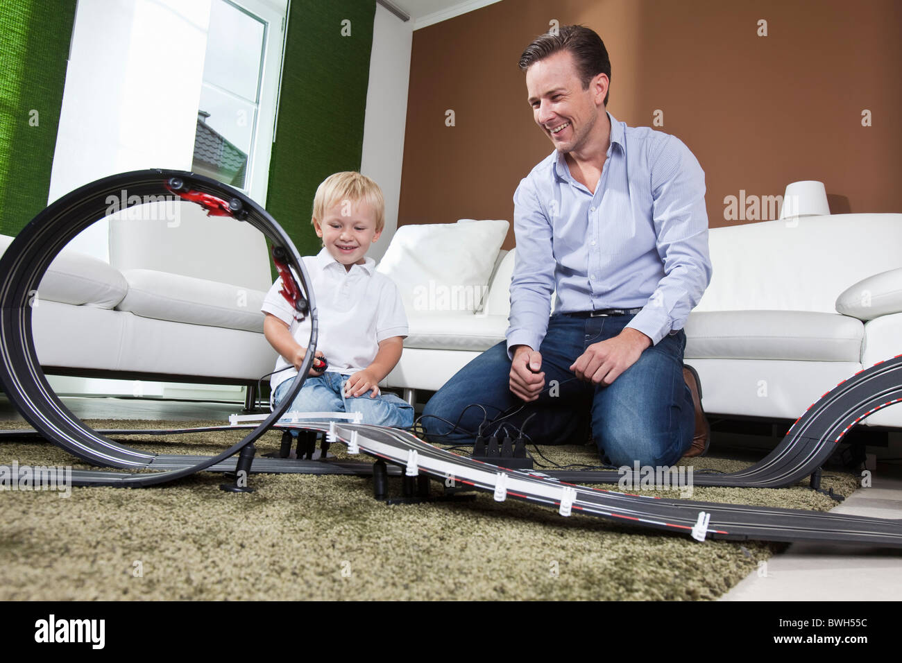 Padre e figlio giocare con race track Foto Stock