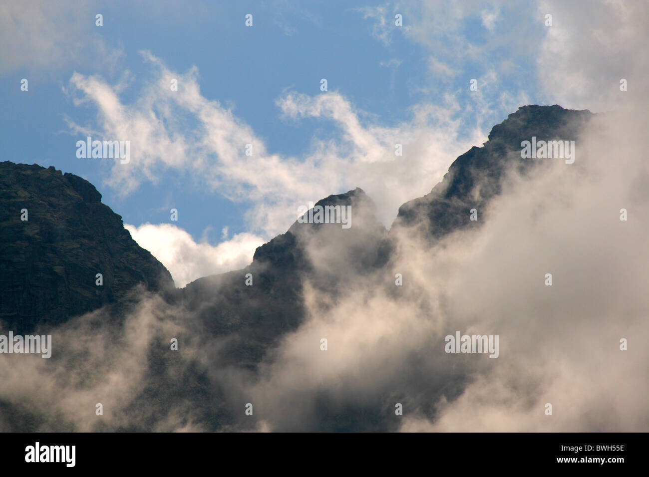 Nuvole ballando davanti a pareti di roccia (Zabi Kon) nelle montagne Tatra, Polonia Foto Stock