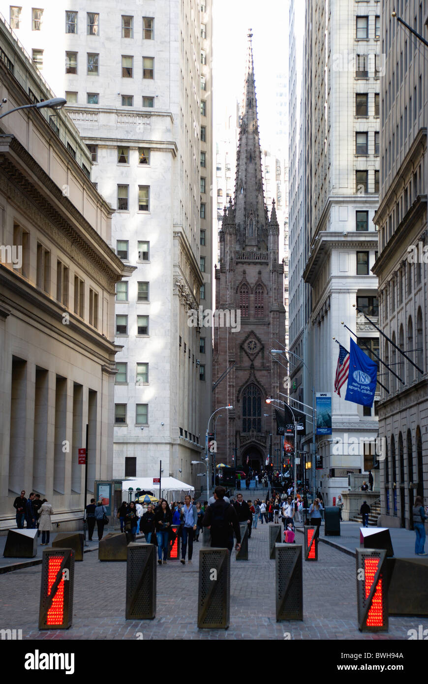 Stati Uniti New York New York Manhattan gotica Chiesa della Trinità con la gente che camminava a Wall Street da barriere di sicurezza Foto Stock