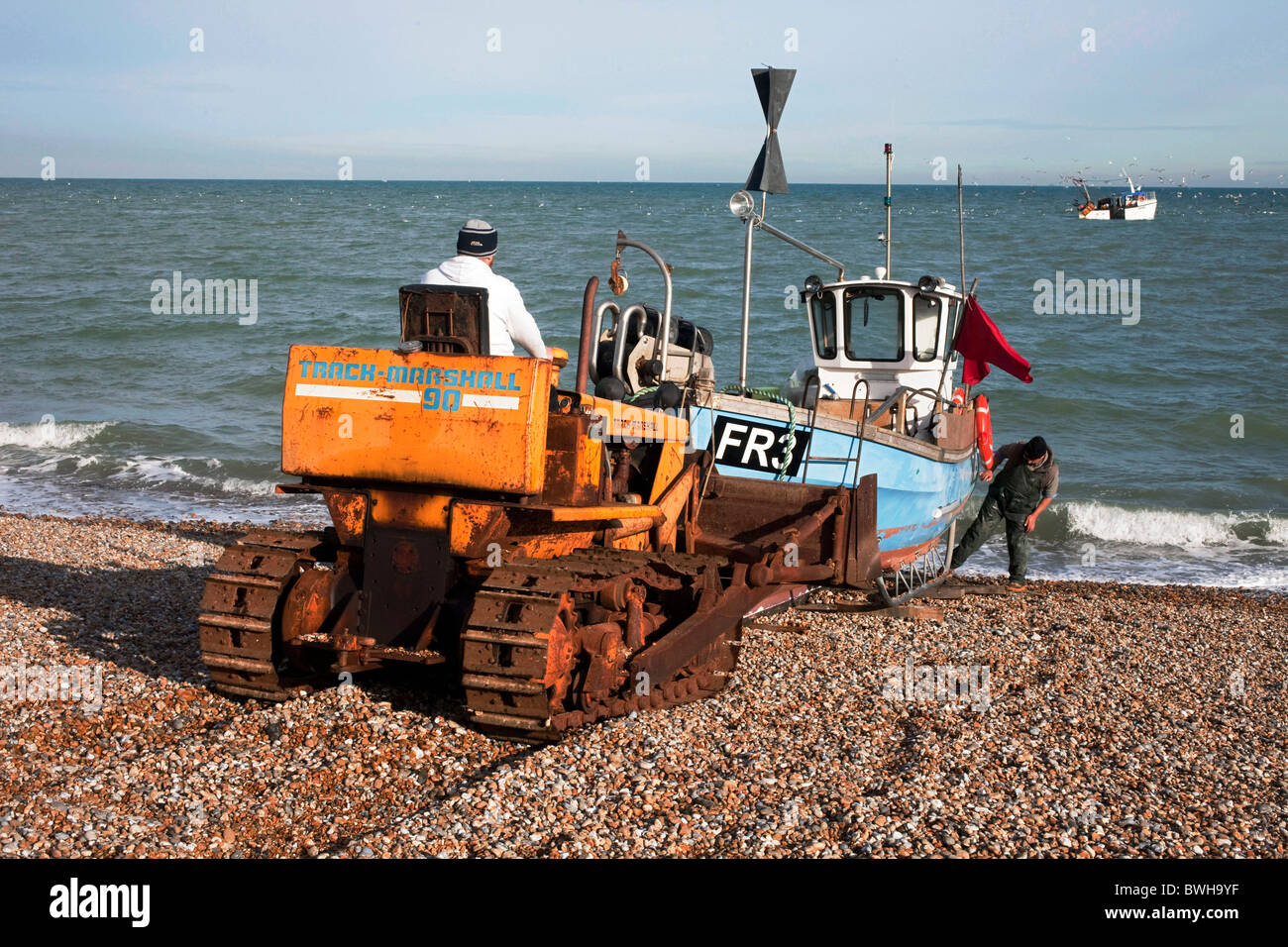 I pescatori costieri Jon Bailey e suo figlio Trevor lanciando la loro piccola barca verso il basso la spiaggia di ciottoli di Dungeness. DAVID MANSELL Foto Stock