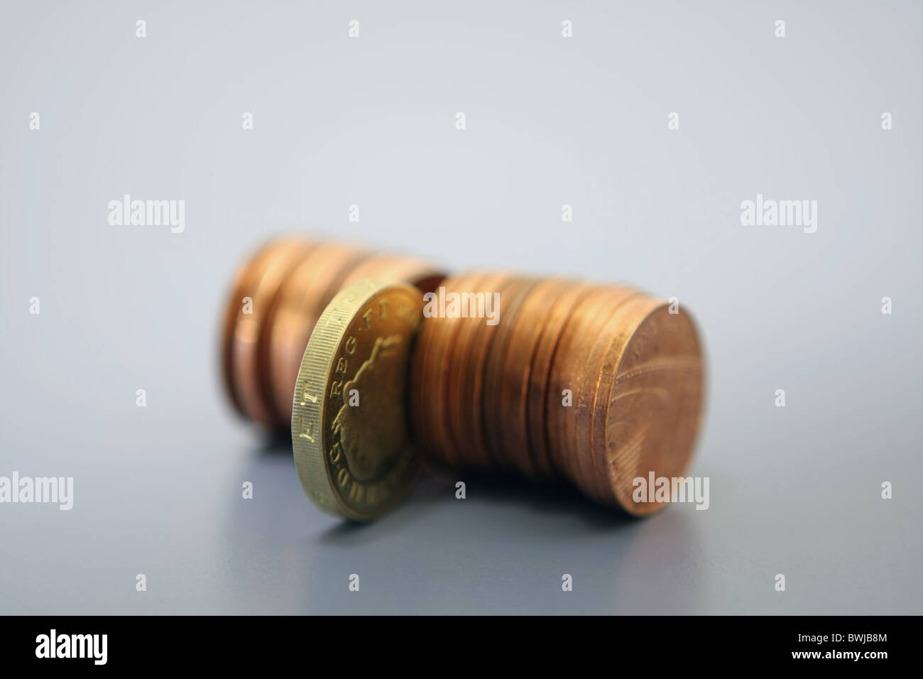 Una sterlina £ 1 moneta nel mezzo di una fila di 1p delle monete in euro Foto Stock