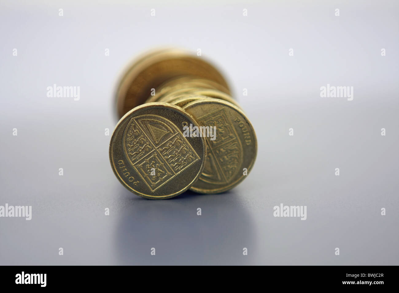Un basso livello di vista di una fila di sterling £2 e £1 monete, concentrandosi sulla parte anteriore £ 1 gettone Foto Stock