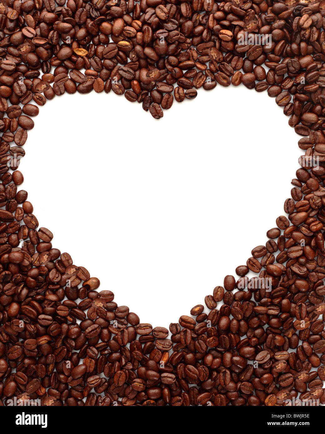 I chicchi di caffè delineano un bianco puro e forma di cuore Foto Stock