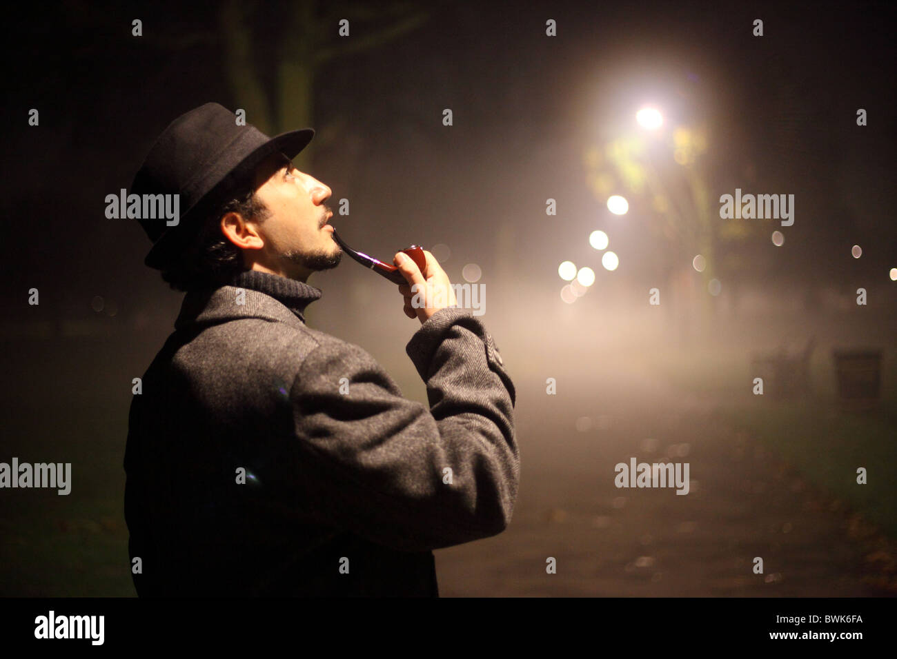 Uomo tubo di fumo nel buio Foto Stock