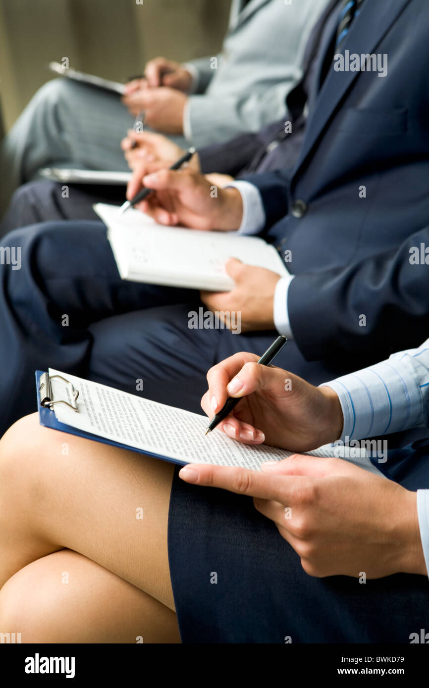 Fila di gente di affari con documenti di seduta alla lezione Foto Stock