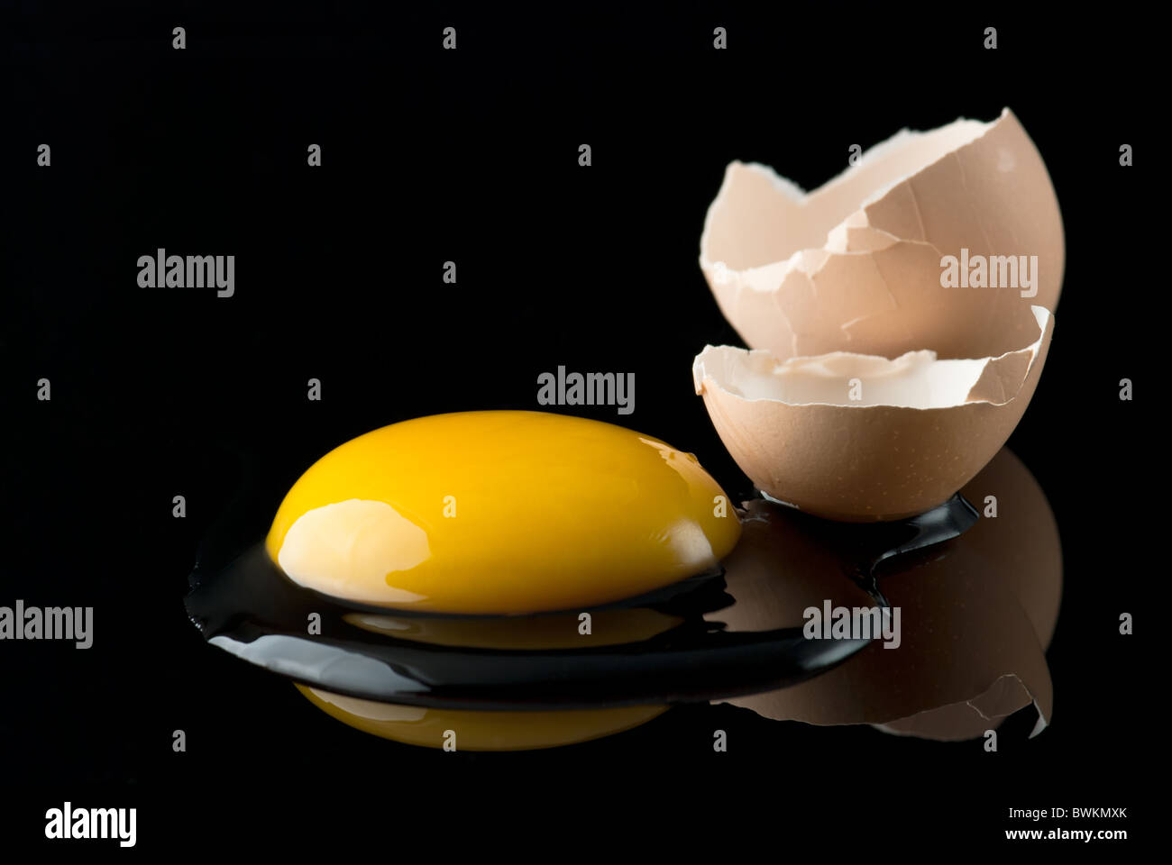 Uovo rotto su nero Foto Stock